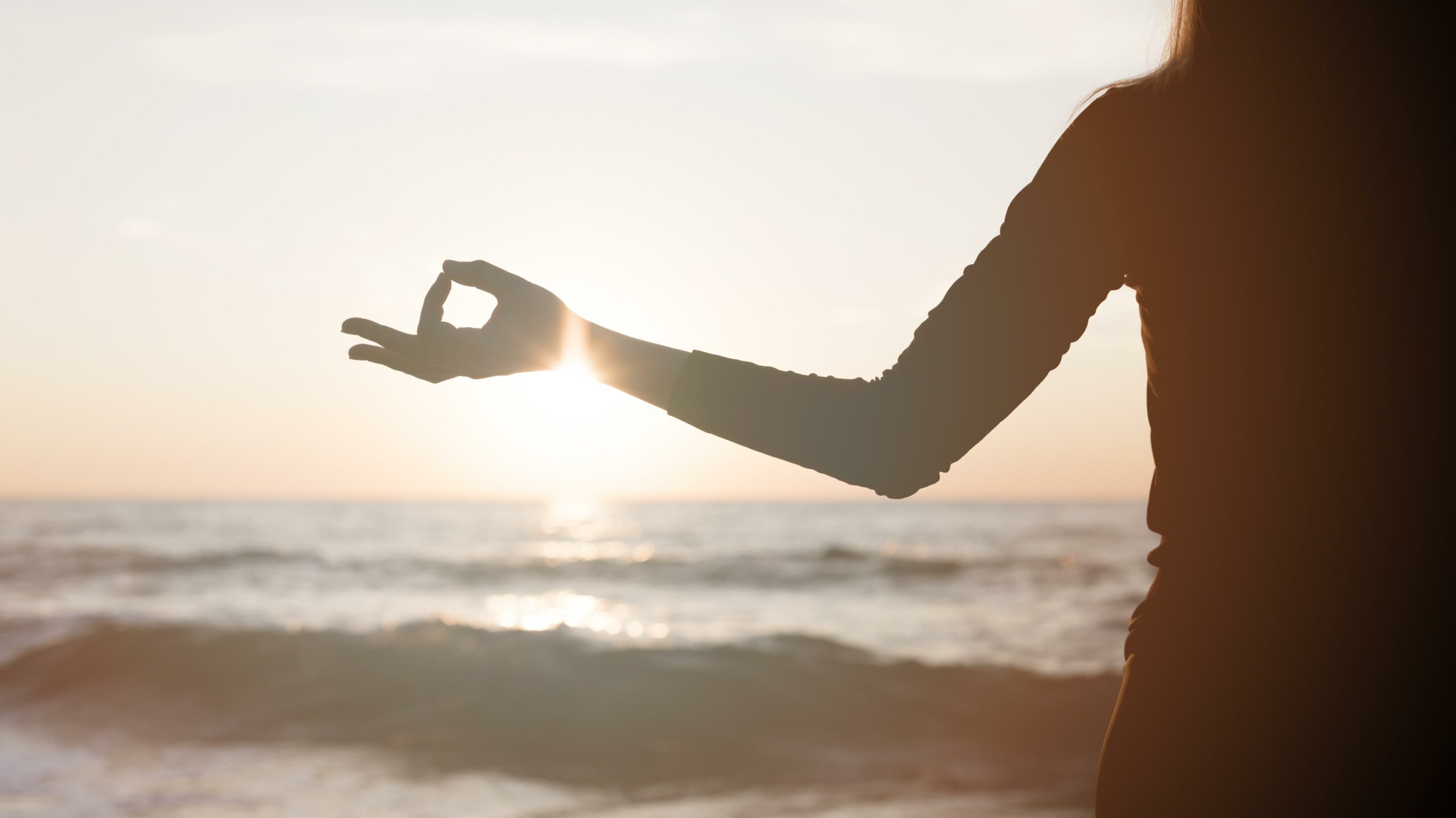 woman-meditating-sunset-beach